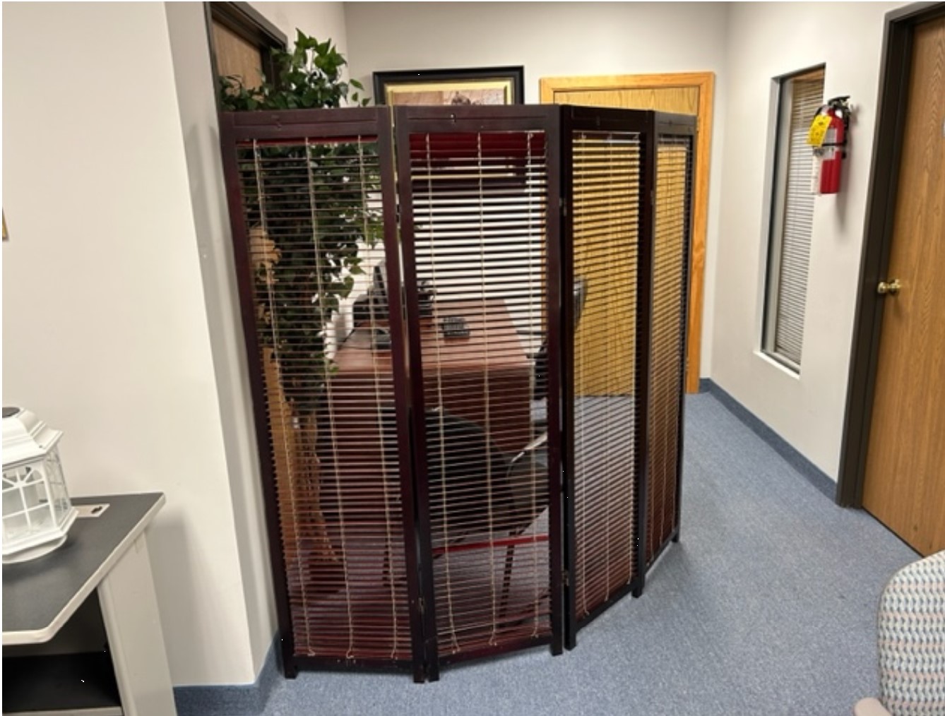A room with a desk and a large screen